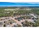 Expansive aerial view of a suburban community nestled amongst a lush green forest and open fields on the horizon at 1766 Summerglow Ln, Monument, CO 80132