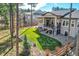 A view of a well landscaped backyard with green lawn, stone accents, mature trees and covered porch at 1766 Summerglow Ln, Monument, CO 80132