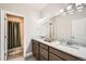 Bright bathroom featuring double sinks, modern lighting fixtures, and a shower with a curtain at 1766 Summerglow Ln, Monument, CO 80132