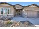 Elegant home exterior with stone accents and a well-manicured front yard at 1766 Summerglow Ln, Monument, CO 80132