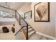 Modern staircase with metal railing leads to the upper level, complemented by a striking bison artwork at 1766 Summerglow Ln, Monument, CO 80132