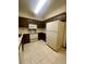 Traditional kitchen featuring tile flooring, a white refrigerator, microwave, range, and wood cabinetry at 12973 E Cornell Ave, Aurora, CO 80014