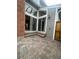 Paver patio featuring a brick accent wall and large sliding glass doors with transom windows at 12973 E Cornell Ave, Aurora, CO 80014
