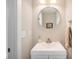 Small bathroom with white vanity, round mirror, and neutral color palette at 921 Raleigh St, Denver, CO 80204
