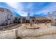 Expansive gravel backyard featuring unique landscaping and a corrugated metal design on the buildings at 410 Goodrich Ave, Platteville, CO 80651