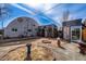 Unique metal building design with backyard firepit, gravel landscaping, and modern shed at 410 Goodrich Ave, Platteville, CO 80651