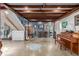 Basement featuring exposed beams, a staircase, eclectic decor, and a variety of musical instruments at 410 Goodrich Ave, Platteville, CO 80651
