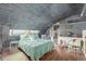 Cozy bedroom showcases unique corrugated metal ceiling and a window for natural light at 410 Goodrich Ave, Platteville, CO 80651