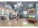 Inviting living room in Quonset-style home with unique decor, modern sofa, and open layout to the kitchen at 410 Goodrich Ave, Platteville, CO 80651