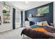 A cozy bedroom featuring a unique geometric patterned comforter and a blue accent wall at 20998 E 60Th Pl, Aurora, CO 80019