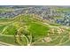 Expansive aerial view of a community park with walking trails, a playground, and vibrant landscaping in a Gathering-friendly setting at 20998 E 60Th Pl, Aurora, CO 80019