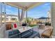 Relaxing outdoor patio featuring cozy seating and a view of the fenced backyard and umbrella-covered table at 20998 E 60Th Pl, Aurora, CO 80019
