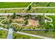 Aerial view showcases a park's play area with sand pit, a bridge, and natural landscaping for community recreation at 20998 E 60Th Pl, Aurora, CO 80019
