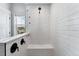 Modern white shower with matte black hardware, a built-in bench and a window at 20998 E 60Th Pl, Aurora, CO 80019