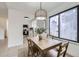 Dining area with modern light fixture, window views, and adjacent kitchen at 1700 W 102Nd Ave, Thornton, CO 80260