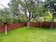 Large backyard featuring lush grass, mature trees, and a wooden privacy fence at 3643 E Lake Dr, Centennial, CO 80121