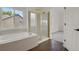 Bright bathroom showcasing a soaking tub, glass enclosed shower, and neutral tiling at 17303 E Dewberry Cir, Parker, CO 80134