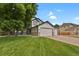 Charming exterior showcasing the lawn and three-car garage on a sunny day at 17303 E Dewberry Cir, Parker, CO 80134