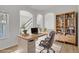 Bright home office with a modern desk, neutral colors, and a bookshelf, creating a serene workspace at 17303 E Dewberry Cir, Parker, CO 80134