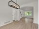 Bright living room with hardwood floors, an archway, and staircase with black railing at 17303 E Dewberry Cir, Parker, CO 80134