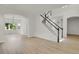 Spacious living room with hardwood floors, an archway, and staircase with black railing at 17303 E Dewberry Cir, Parker, CO 80134
