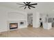 Bright living room featuring a fireplace and an open layout into the kitchen, with hardwood flooring at 17303 E Dewberry Cir, Parker, CO 80134