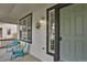 Cozy porch with seating and a charming entrance door, framed by black trim windows at 17303 E Dewberry Cir, Parker, CO 80134