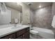 Stylish bathroom featuring vanity with modern fixtures and bathtub with tiled walls at 8244 S Queen St, Littleton, CO 80127