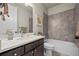 Modern bathroom featuring stylish vanity, bathtub with stone-look tile surround, and sleek fixtures at 8244 S Queen St, Littleton, CO 80127