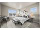 Well-lit bedroom with a large bed, a cozy chair, and neutral decor for a serene atmosphere at 8244 S Queen St, Littleton, CO 80127