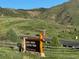 Sign at entrance of Deer Creek Canyon Park, near homes and natural scenery at 8244 S Queen St, Littleton, CO 80127