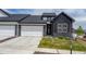 Modern townhome with a dark exterior, a two-car garage, and newly installed landscaping at 8244 S Queen St, Littleton, CO 80127
