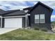 Modern home showcasing black and white exteriors, a white garage door, and manicured lawn at 8244 S Queen St, Littleton, CO 80127