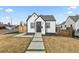 Charming home featuring black trim, modern landscaping, and a welcoming walkway leading to the front door at 75 S Knox Ct, Denver, CO 80219