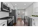 Bright kitchen features stainless steel appliances, white cabinetry, and hardwood floors at 75 S Knox Ct, Denver, CO 80219
