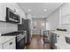 Bright kitchen with stainless steel appliances and white cabinets at 75 S Knox Ct, Denver, CO 80219