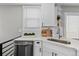 Updated kitchen with white cabinetry, marble counters, and a stainless steel dishwasher at 75 S Knox Ct, Denver, CO 80219