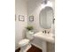 Modern powder room with pedestal sink, oval mirror, and dark accents at 6071 S Oswego St, Greenwood Village, CO 80111