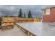 Comfortable back patio area featuring a stone bench and a lit fire pit at 13601 Krameria St, Thornton, CO 80602