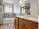 Bathroom with double vanity, decorative tile, and separate bathtub and shower at 13601 Krameria St, Thornton, CO 80602