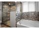 Elegant bathroom with a glass-enclosed shower and a soaking tub at 13601 Krameria St, Thornton, CO 80602