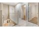 Bright hallway featuring a white staircase, tiled floors, and doorways leading to other rooms at 13601 Krameria St, Thornton, CO 80602