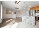 Open layout showing the kitchen with an island, stainless appliances and a view into the living area at 13601 Krameria St, Thornton, CO 80602