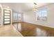 Bright, open-concept living room features gleaming hardwood floors and abundant natural light from large windows at 13601 Krameria St, Thornton, CO 80602