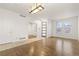 The bright living room features hardwood floors, white walls, a contemporary light fixture and large sunny windows at 13601 Krameria St, Thornton, CO 80602