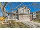 Two-story house with a beige exterior, a two-car garage, and a well-manicured lawn at 5545 E 130Th Dr, Thornton, CO 80241