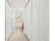 Hallway view leading to the bathroom with ample closet space and neutral carpeting at 3329 Molly Ln, Broomfield, CO 80023