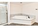 Bright bathroom featuring a soaking tub with a marble backsplash and a glass-enclosed shower at 12024 W Cross Dr # 106, Littleton, CO 80127
