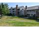 Multi-story apartment complex with grassy lawn, mature trees, and well-kept landscaping in the community at 12024 W Cross Dr # 106, Littleton, CO 80127