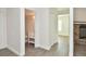 Hallway featuring access to the bathroom, closets, and living area with stone fireplace at 12024 W Cross Dr # 106, Littleton, CO 80127